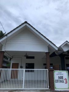 una casa con un cartello di vendita davanti di Abe.Cottage 3 a Kampong Chawat