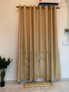 a gold curtain in a room with a plant at Abe.Cottage 3 in Kampong Chawat