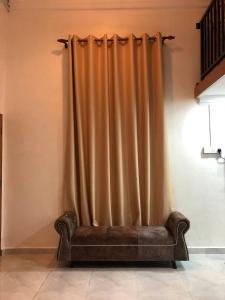 a couch sitting in a room with a curtain at Abe.Cottage 3 in Kampong Chawat