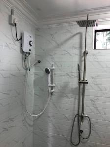 a shower with a glass door in a bathroom at Abe.Cottage 3 in Kampong Chawat