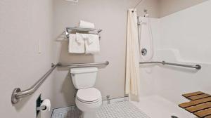 a bathroom with a toilet and a shower with towels at Lighthouse Suites Inn in Ocean Shores