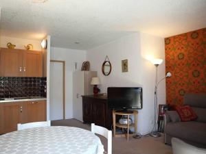 a room with a bed and a kitchen with a television at Appartement Les Orres, 1 pièce, 4 personnes - FR-1-322-219 in Les Orres