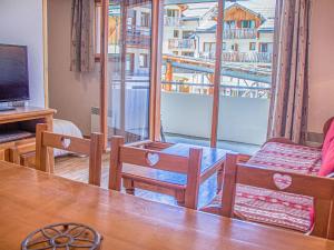 ein Wohnzimmer mit einem Tisch und Stühlen sowie einem Balkon in der Unterkunft Appartement Les Orres, 2 pièces, 6 personnes - FR-1-322-330 in Les Orres