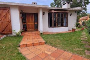 une maison avec une porte et une pelouse dans l'établissement Hermosa casa de espacios amplios, à Punta del Este