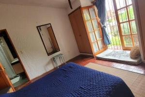 - une chambre avec un lit bleu et un miroir dans l'établissement Hermosa casa de espacios amplios, à Punta del Este