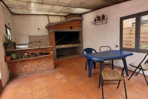 une cuisine avec une table bleue et une cheminée en briques dans l'établissement Hermosa casa de espacios amplios, à Punta del Este