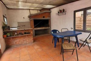 cocina con mesa azul y chimenea de ladrillo en Hermosa casa de espacios amplios, en Punta del Este