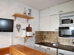 kuchnia z białymi szafkami, zlewem i kuchenką mikrofalową w obiekcie Studio 4 pers en cœur de station, balcon vue montagne - FR-1-322-500 w mieście Les Orres