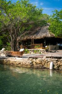 eine Hütte mit einem Boot neben einem Wasserkörper in der Unterkunft Hotel Coralina Island in Isla Grande