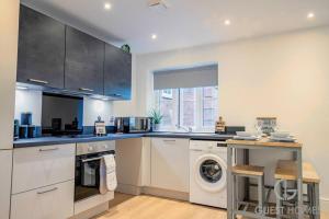 a kitchen with a washing machine and a washer at Guest Homes - Sedlescombe Apartment in Rugby