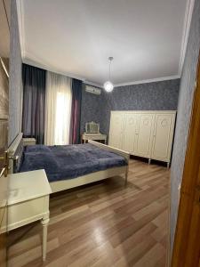 a bedroom with a bed and a desk and a table at City Center Apartment in Kutaisi