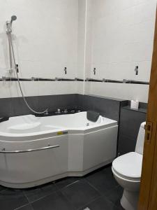 a bathroom with a white tub and a toilet at City Center Apartment in Kutaisi