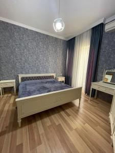 a bedroom with a bed with a blue comforter at City Center Apartment in Kutaisi