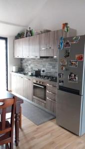 a kitchen with a stainless steel refrigerator and a table at Casa Fissore in Sommariva Perno