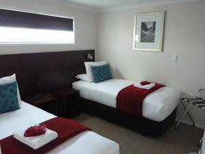 um quarto de hotel com duas camas e uma janela em Astra Motor Lodge em Hamilton