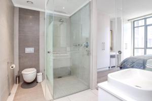 a bathroom with a shower and a toilet and a sink at Urban Oasis Apartments at Masingita Towers in Johannesburg +12 photos