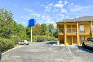 a car parked in a parking lot next to a building at Bonita Lakes Inn by Capital O Meridian I20 in Meridian