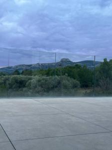 un court de tennis avec des arbres et des montagnes en arrière-plan dans l'établissement Villa d’exception, à Gémenos