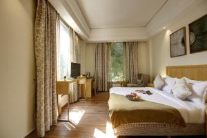 a hotel room with a bed and a large window at Saltstayz Corporate Suite- Golf Course Road and Near galleria market in Gurgaon