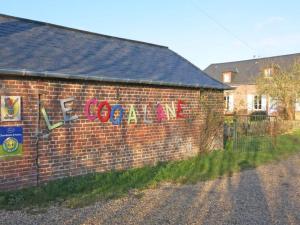 a brick building with the word excellence painted on it at Chambres d'hôtes du Coq à l'Ane in Beaubec-la-Rosière