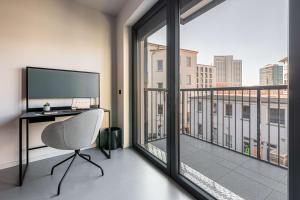 ein Büro mit einem Schreibtisch und einem großen Fenster in der Unterkunft YUMA Apartments Leipzig Berliner Straße in Leipzig