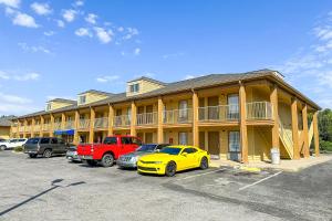 a yellow car parked in front of a building at Bonita Lakes Inn by Capital O Meridian I20 in Meridian