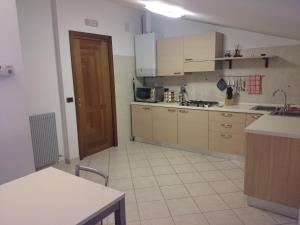 una cucina con armadi marroni e pavimento piastrellato bianco di Ciclaminis a Nimis