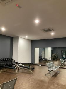 un gimnasio con varias cintas de correr y sillas en una habitación en Vista Bangi NAQ Homestay - Studio Near UKM, en Kajang