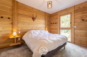 um quarto com paredes de madeira e uma cama num quarto em Chalet Escal em Les Angles