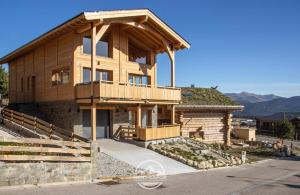 uma casa de madeira com uma varanda em cima em Chalet Escal em Les Angles