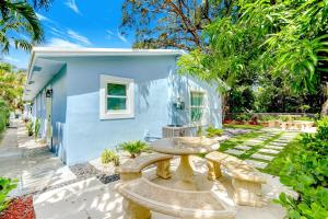 a blue house with a table and benches in a yard at Modern Rental - Pet-Friendly, Free Parking in Hollywood