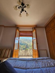 una camera con letto e finestra con vista di CASA CARMELA a Quéntar