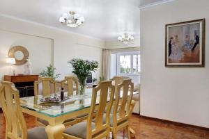 a dining room with a glass table and chairs at Central Living Funchal in Funchal +16 photos
