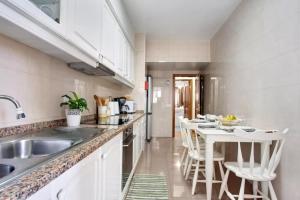 a kitchen with a sink and a table with chairs at Central Living Funchal in Funchal