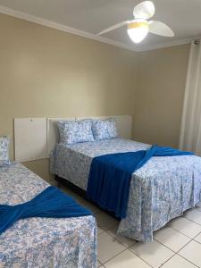 una camera con 2 letti e un ventilatore a soffitto di Lindo apartamento ad Aracaju