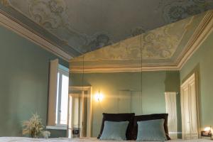 a bedroom with a bed with a ceiling and a mirror at Madamin 