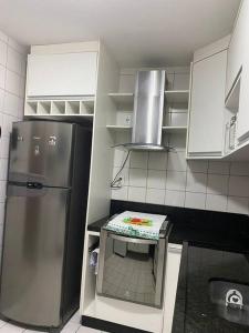 a kitchen with a refrigerator and a table in it at Lindo apartamento in Aracaju