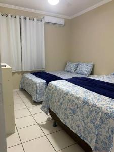 a bedroom with two beds and a window at Lindo apartamento in Aracaju