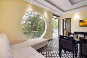 a living room with a white couch and a round window at Four Spring Villas & Golfs Da Lat in Da Lat