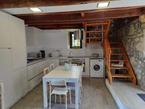 uma cozinha com uma mesa e cadeiras e uma escada em Casinha Nº461 em Vila Praia de Âncora