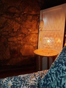 a lamp sitting on a table next to a bed at Casinha Nº461 in Vila Praia de Âncora