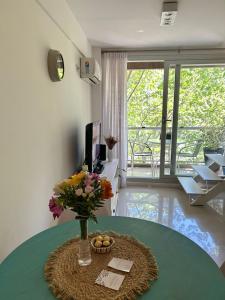 una habitación con una mesa con un jarrón de flores en Depto Oro - Palermo Nuevo en Buenos Aires