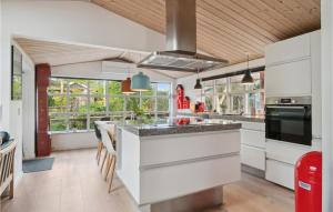 uma cozinha com armários brancos e uma grande ilha em Lovely Home In Grlev With House A Panoramic View em Reersø