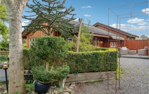 una casa con arbustos y un árbol delante de ella en Lovely Home In Grlev With House A Panoramic View en Reersø