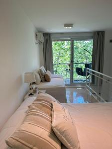 a bedroom with two beds and a large window at Depto Oro - Palermo Nuevo in Buenos Aires