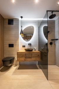 y baño con lavabo, bañera y espejo. en Kellnergut Luxus-Chalet "FRIEDA", en Mühlbach am Hochkönig
