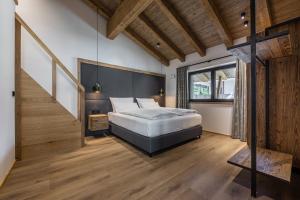 a bedroom with a large bed and a staircase at Kellnergut Luxus-Chalet "FRIEDA" in Mühlbach am Hochkönig
