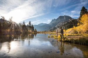 a man is standing on the shore of a river at Courchevel #5 condo in Mammoth Lakes