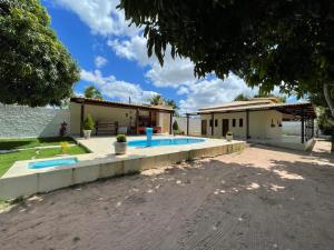 uma casa com piscina junto à água em Pousada MKC em São Gonçalo do Amarante