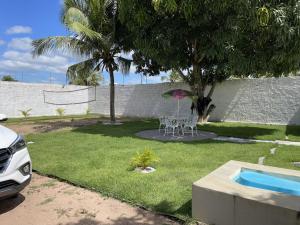 um quintal com uma mesa e cadeiras e uma piscina em Pousada MKC em São Gonçalo do Amarante